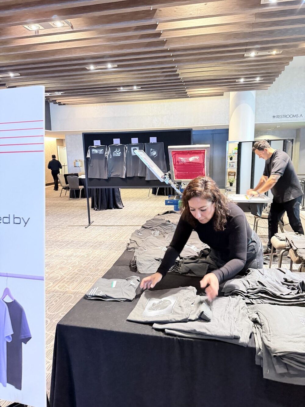 An elevated view of a live screen-printing activation drawing a crowd at a New York convention-style event