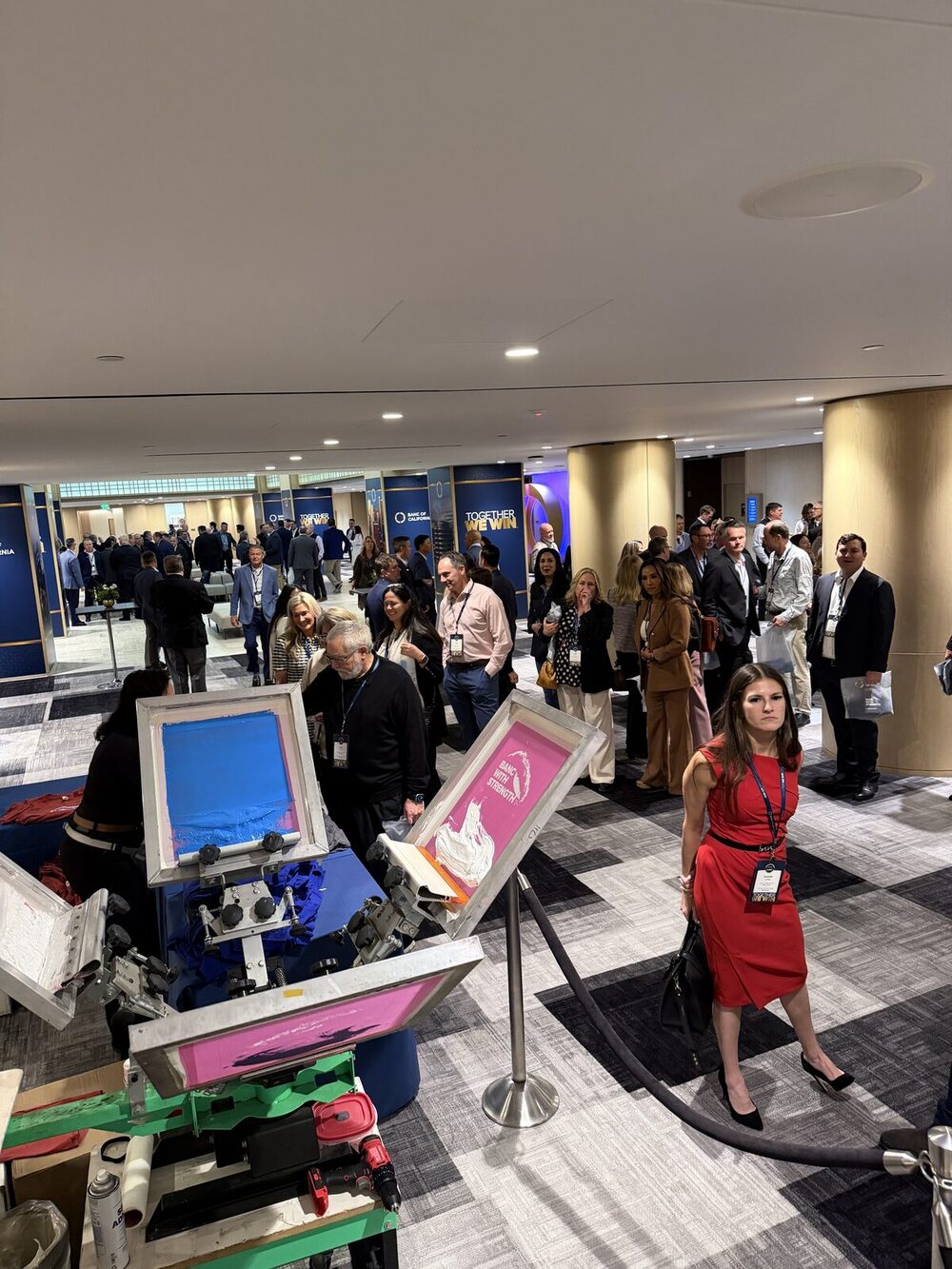 An elevated view of a live screen-printing activation drawing a crowd at a New York convention-style event
