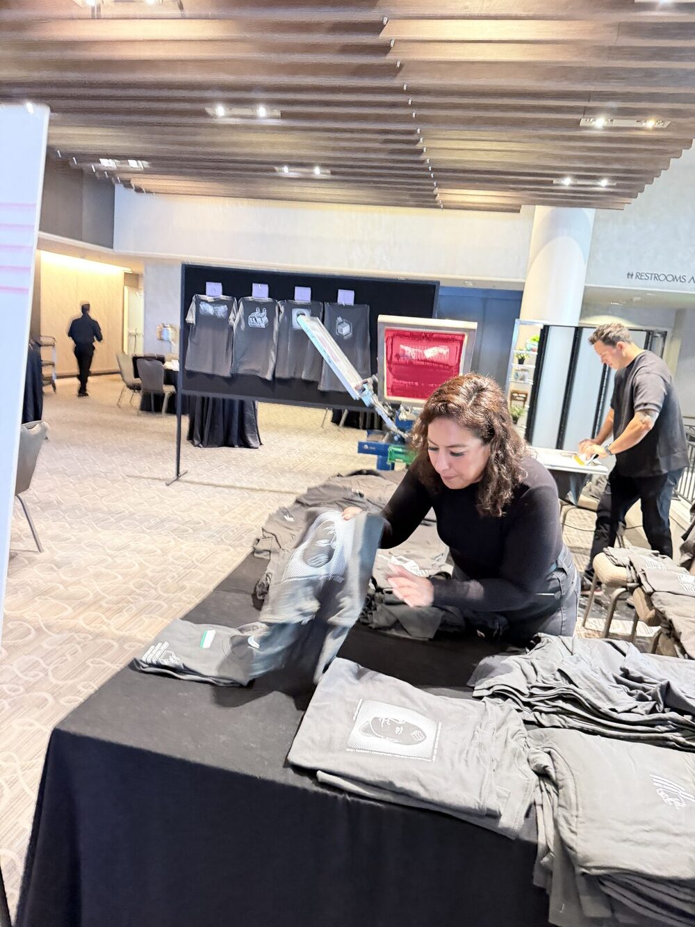 An elevated view of a live screen-printing activation drawing a crowd at a New York convention-style event