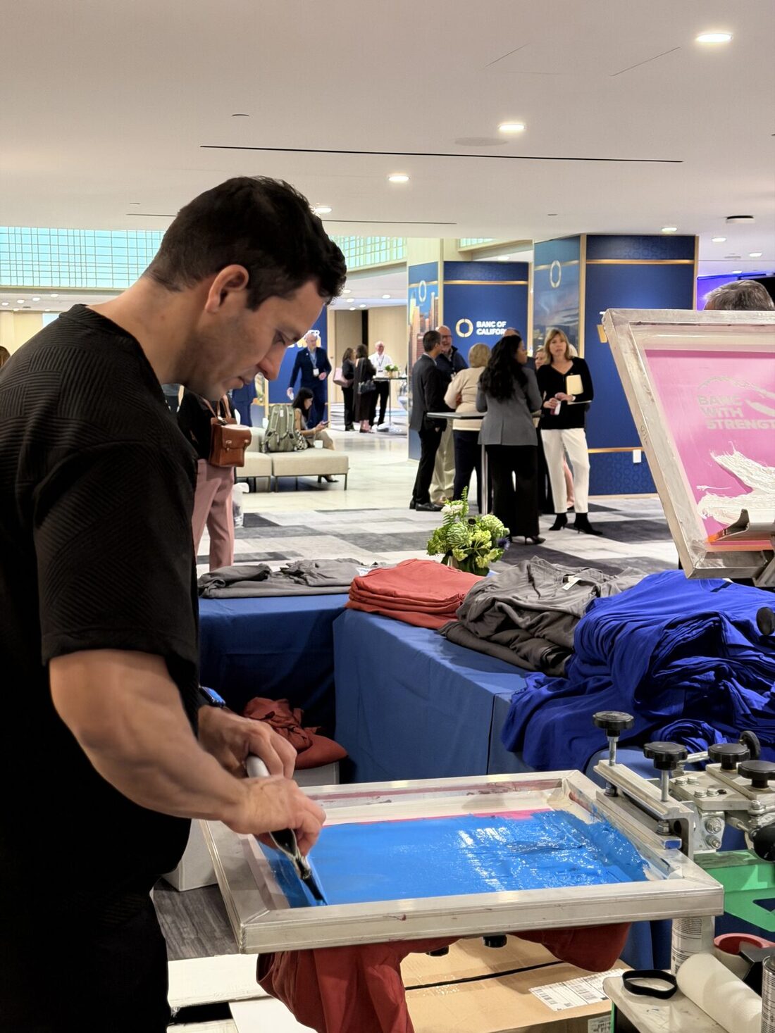 An elevated view of a live screen-printing activation drawing a crowd at a New York convention-style event